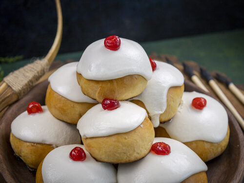 Brioche avec un glaçage au sucre glace et une cerise confite dessus